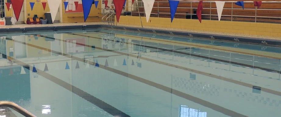 Fairport High School indoor pool with lane lines and red, white, and blue backstroke flags